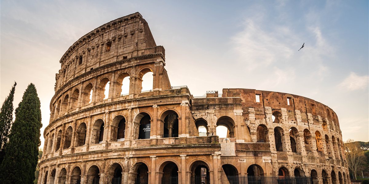 Le Colisée de Rome au lever du soleil, lumière dorée sur les arches antiques